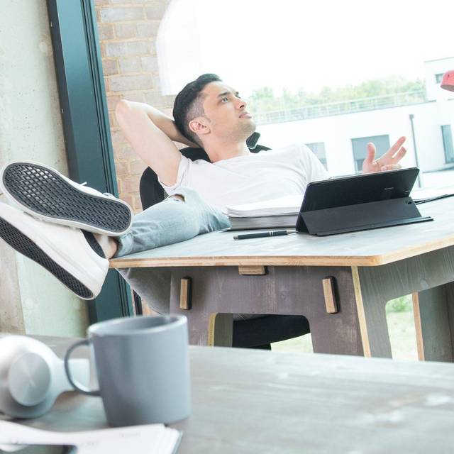 Mann schaut an seinem Schreibtisch aus dem Fenster