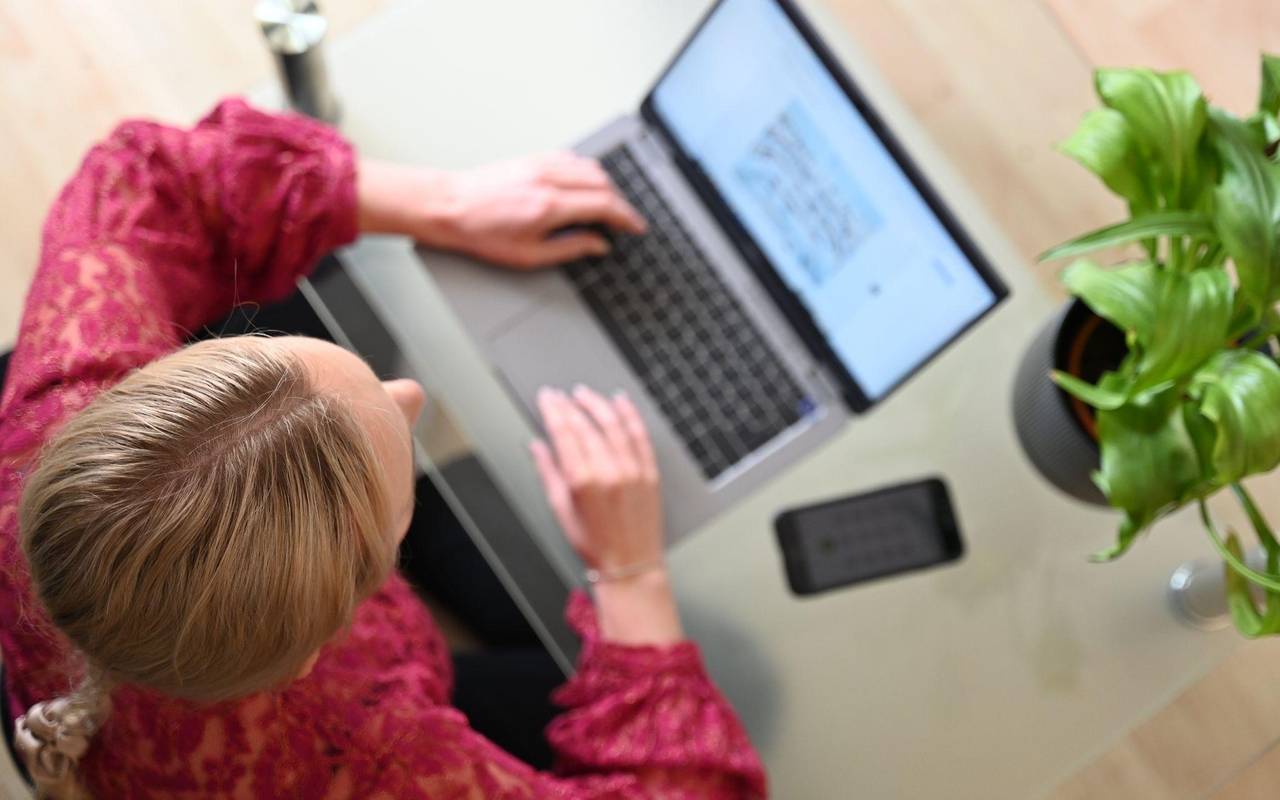 Eine Frau sitzt zuhause an einem Laptop