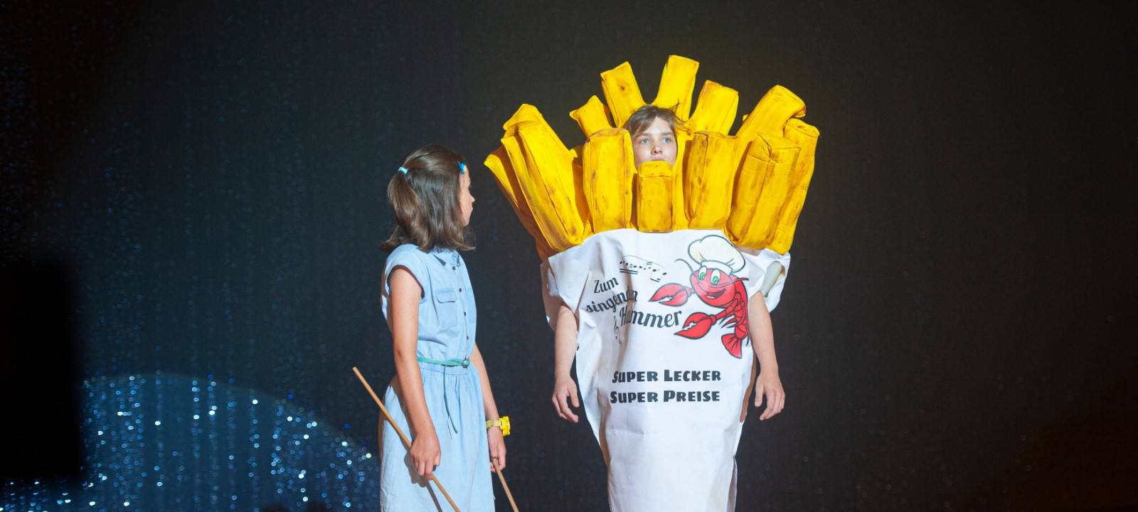 Als Pommes verkleidet auf der Bühne - für ihren nächsten Fall geben die Detektive alles.