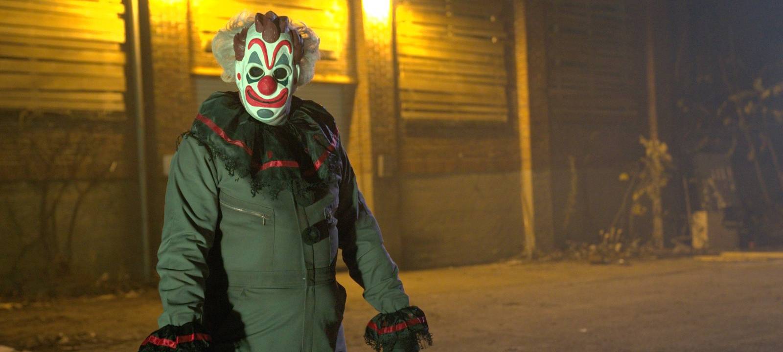 Ein Clown empfängt die Truppe vor dem Haus