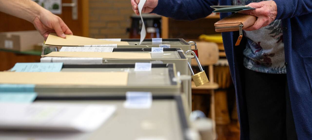 Eine Person gibt seine Stimme bei einer Wahl ab.